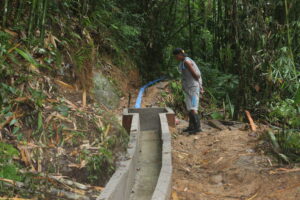 A beneficiary inspects the irrigation drop box